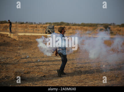 La striscia di Gaza, la Palestina. Xx Settembre, 2019. Un dimostrante palestinese getta indietro una lacrima di bombole di gas durante un anti-Israele dimostrazione presso il Israel-Gaza recinzione di confine nel sud della striscia di Gaza. Credito: SOPA Immagini limitata/Alamy Live News Foto Stock