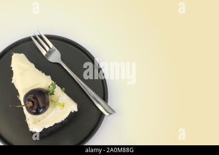 Birra nera torta. Un pezzo di torta nera con sapore di birra e rabboccato con crema di formaggio e di ciliegio Foto Stock