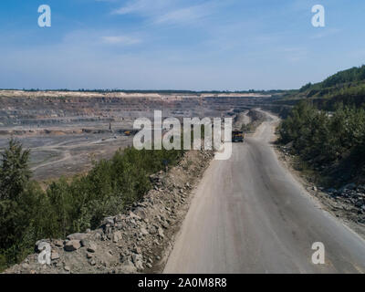 Industriale enorme camion in una grande cava di pietra caricato il trasporto di marmo o granito sparato da un drone Foto Stock