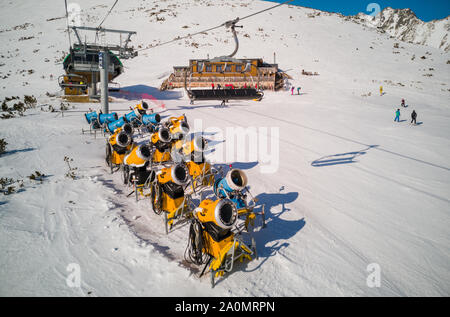 Giallo cannoni da neve sul pendio nel periodo invernale. Foto Stock