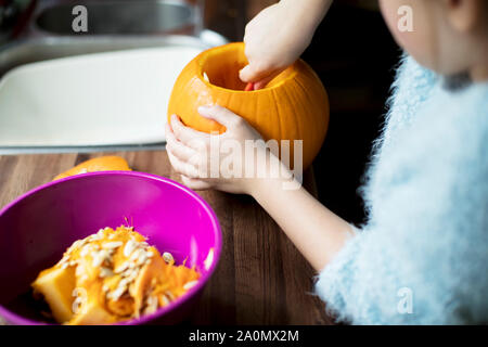 Close up girl scavare la zucca per rendere Lanterna di Halloween Foto Stock