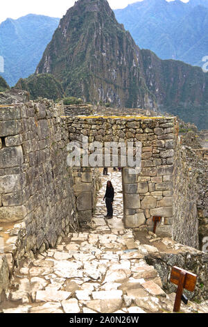 Machu Picchu è una cittadella Inca è impostata su un livello elevato nella catena delle Ande in Perù, sopra il fiume Urubamba valley. Costruito nel XV secolo e successivamente abbandonato, è rinomato per la sua sofisticata muretti a secco che il fusibile enormi blocchi senza l'uso di mortaio, intriganti edifici che giocare su allineamenti astronomici e viste panoramiche. Il suo esatto ex uso rimane un mistero. Esso si erge 7,970 piedi (2.430 metri sopra il livello del mare sul versante orientale delle Ande Foto Stock