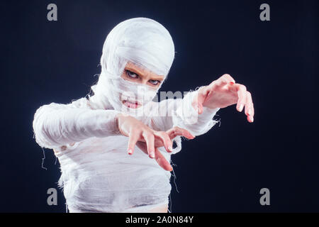 Mummia glamour donna in bende in tutto il suo corpo in studio su sfondo nero. Festa di Halloween o chirurgia plastica concetto di vittima. Foto Stock