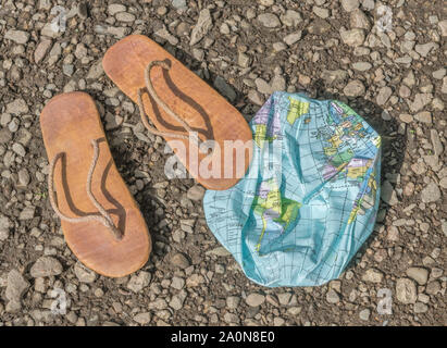 Indossato hippy flipflops & globo sgonfiato sulla superficie di scandole. Metafora terra piatta, flat earthers, teorie cospirative, piano terra prove, pseudoscience Foto Stock