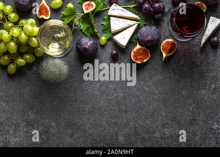 Bicchieri di vino rosso e bianco con formaggio, uva e fichi Foto Stock