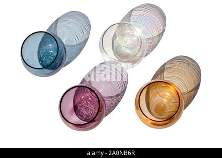 Quattro vintage multicolore bicchieri arrotondati su uno sfondo bianco con belle ombre colorate in presenza di luce solare isolato vicino la vista superiore Foto Stock