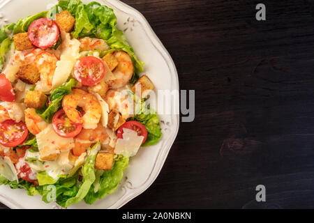 Gamberetti insalata Caesar con formaggio parmigiano, crostini, pomodorini e lattuga, close-up shot di overhead con spazio di copia Foto Stock