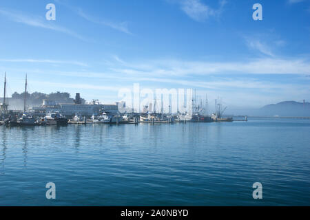 SAN FRANCISCO, CALIFORNIA, STATI UNITI - Novembre 26th, 2018: Pesca barche ormeggiate San Francisco Pier 39 con il Golden Gate Bridge in background Foto Stock