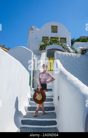 Ragazza giovane salite le scale per la costruzione, la Grecia, l'isola di Santorini Foto Stock