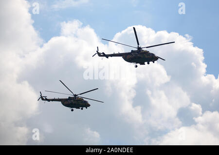 Novosibirsk, Russia, luglio 31, 2016 Mochishche airfield, locale air show, due elicotteri militari Mi-8 sul cielo blu con nuvole bianche sullo sfondo Foto Stock