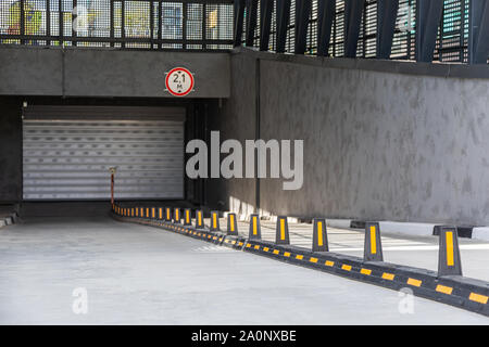 Ingresso al garage sotterraneo con rullo-porta ad otturatore e divisori per circolazione su strada Foto Stock