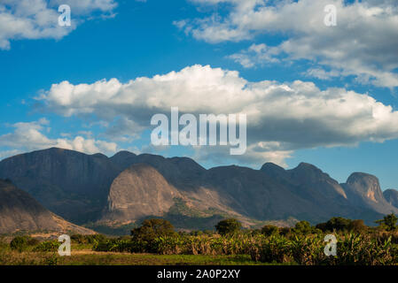 Una gamma di montagna sorge su una lussureggiante vegetazione in Mozambico, Africa Foto Stock