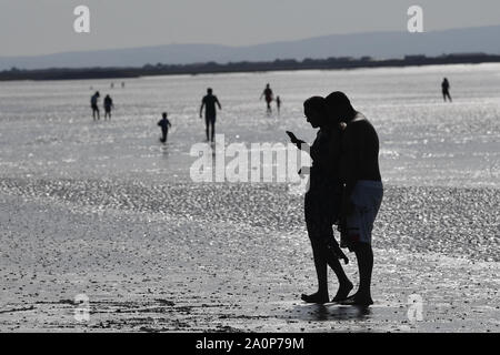 Persone godetevi il sole sulla spiaggia di Weston-super-Mare, come le temperature sono attesi per volare a 26C in alcune parti del paese questo fine settimana. Foto Stock