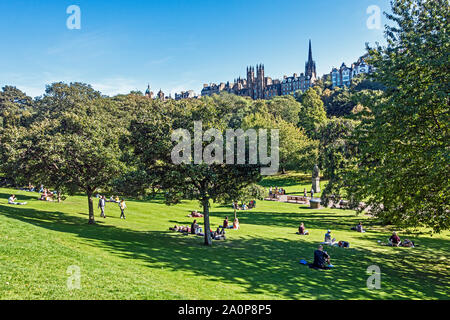 Le persone che si godono il sole in settembre nei giardini di Princes Street east Edinburgh Scotland Regno Unito Foto Stock