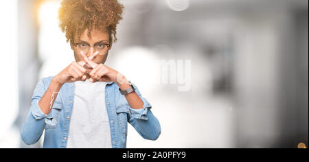 Bella giovane americano africano donna che indossa gli occhiali su sfondo isolato rifiuto espressione dita incrociate facendo segno negativo Foto Stock