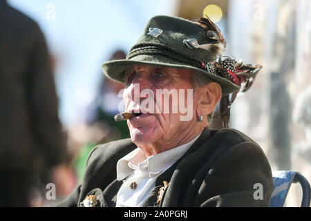 Monaco di Baviera, Germania. Xxi Sep, 2019. Data di inizio della Oktoberfest. Un supporto proprietario fumatori si siede accanto al suo stand di souvenir. Il più grande festival folk del mondo dura fino al 6 ottobre. Credito: Tobias Hase/dpa/Alamy Live News Foto Stock