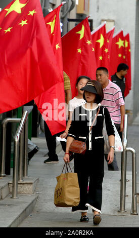 Pechino, Cina. Xxi Sep, 2019. Cinese passato a piedi negozi adornata con il paese della bandiera nazionale a Pechino il Sabato, Settembre 21, 2019. Cina Partito Comunista è stato in overdrive promuovere il patriottismo e il nazionalismo di venire nel paese il settantesimo anniversario il 1 ottobre. Foto di Stefano rasoio/UPI Credito: UPI/Alamy Live News Foto Stock