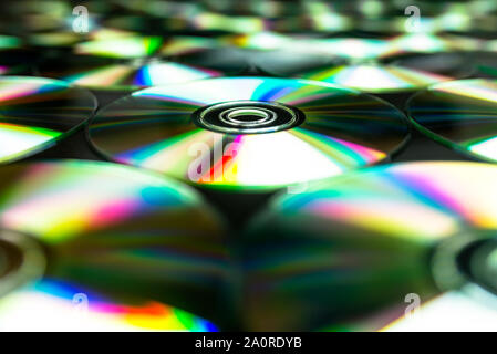 Cd / DVD giacente su un fondo nero con riflessi colorati di luce. Foto Stock
