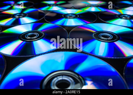 Cd / DVD giacente su un fondo nero con riflessi colorati di luce. Foto Stock