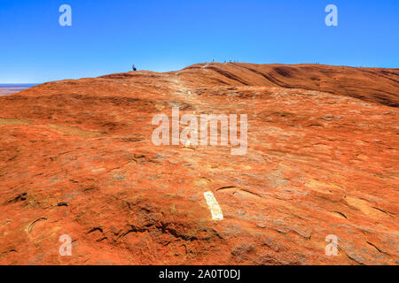 Uluru, Territorio del Nord, l'Australia - Agosto 23, 2019: Orientamenti verniciate lungo il trekking sulla cima di Ayers Rock in Uluru-Kata Tjuta National Park.L Foto Stock