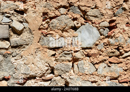 Frammento di un antico muro illuminato dal sole luminoso di close-up. Muro di pietra dello sfondo. Foto Stock