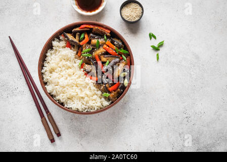 Mescolare melanzane fritte e peperone e riso in bianco, vista dall'alto, copia dello spazio. Asian cibo cinese. Vegano pasto sano. Foto Stock