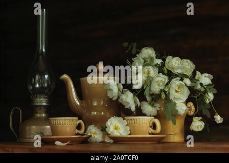 Still-life di argilla tazze di caffè con un fresco e rose bianche Foto Stock