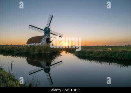 Il mulino a vento e decadente casa in campagna olandese vicino a Leiden, Olanda al tramonto Foto Stock