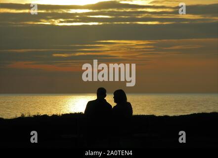 Un paio di guardare il sole al tramonto, Seascale, Cumbria, England, Regno Unito Foto Stock