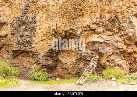 Fotografia a colori della cava scogliera con singolo legno scaletta improvvisata poggiante sulla roccia, preso in Kenya. Foto Stock