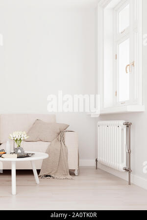 Mock up muro beige con divano bianco, due tabelle e una sedia in arredamento moderno sfondo, soggiorno con ampia finestra con un radiatore, Scandinavian styl Foto Stock