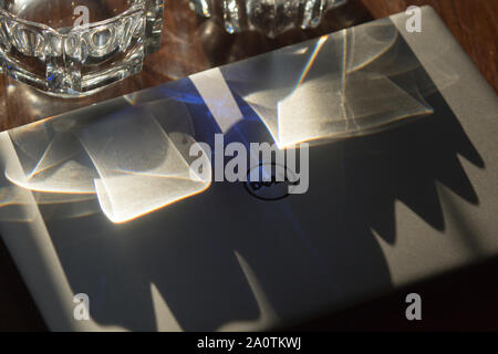 Vista dall'alto di un Dell XPS ultrabook con chiusura coperchio in alluminio lavato con raggi solari tramite crystal houseware, su di un tavolo di legno. Foto Stock