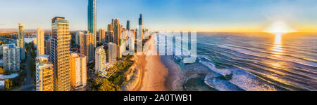Luminosa alba oltre oceano Pacifico orizzonte in vista della spiaggia di sabbia e il mare di Surfers paradise e il CBD su Australian Gold Coast - ampia panoram antenna Foto Stock
