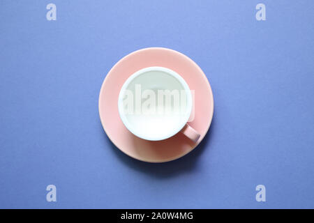 Pink coffee cup on purple background Foto Stock