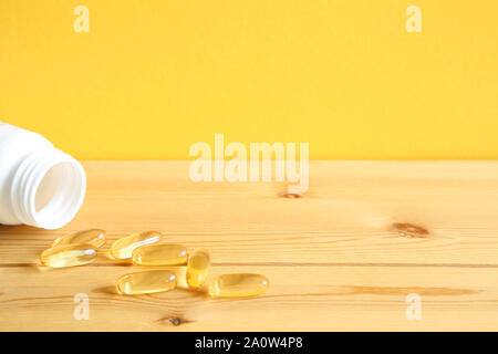 Omega 3 capsule supplemento sano pillole con bottiglia sul tavolo di legno Foto Stock