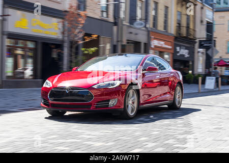 Tesla Model S guida attraverso un urbano centro citta'. Foto Stock