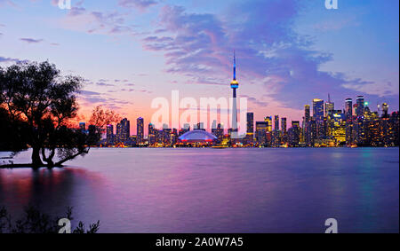 Toronto waterfront syline al crepuscolo, CN Tower in blu e giallo di illuminazione. Foto Stock