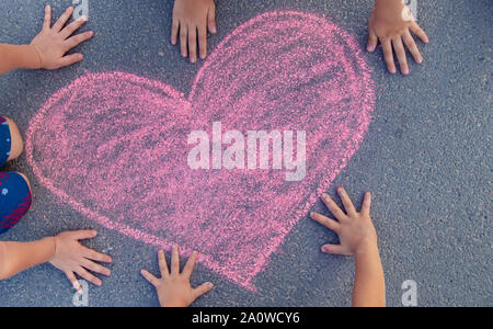 Bambini i disegni su asfalto con Chalk. Messa a fuoco selettiva. la natura. Foto Stock