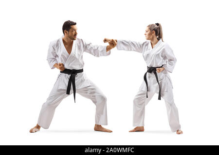 A piena lunghezza shot di un uomo e di una donna con cinture nere nel karate lotta isolata su sfondo bianco Foto Stock