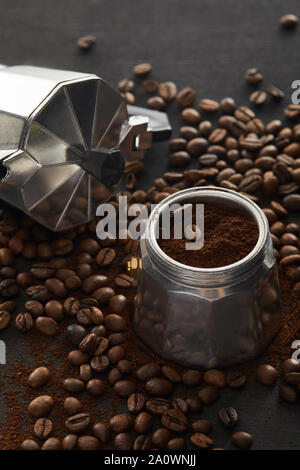 Geyser macchinetta da caffè in legno marrone scuro e superficie con i chicchi di caffè Foto Stock