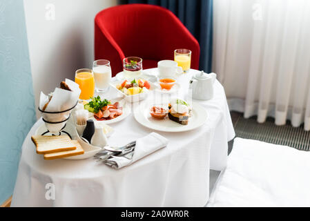 Una gustosa prima colazione vicino a vetri con succo di arancia e il latte sul tavolo Foto Stock