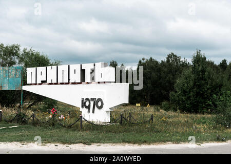 Pripjat, Ucraina - Agosto 15, 2019: monumento con pripjat lettere nei pressi di alberi al di fuori Foto Stock