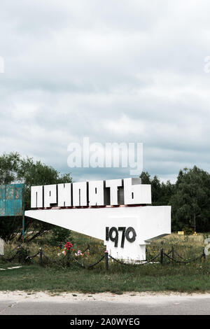 Pripjat, Ucraina - Agosto 15, 2019: monumento con pripjat scritte nei pressi di alberi al di fuori Foto Stock