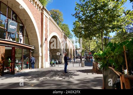 A livello di strada negozi sotto la Promenade Plantee, una verde a piedi nel dodicesimo arrondissement seguendo il vecchio Vincennes linea ferroviaria, Paris, Francia. Foto Stock