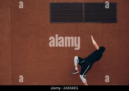 Parkour giovane uomo facendo acrobazie e trick flip jumping alta Foto Stock