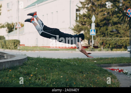 Parkour giovane uomo facendo acrobazie e trick flip jumping alta Foto Stock