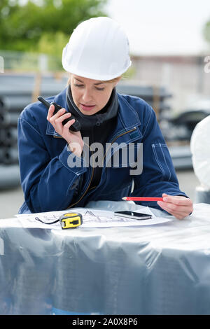 Lavoratore di sesso femminile che utilizzano walkie Foto Stock