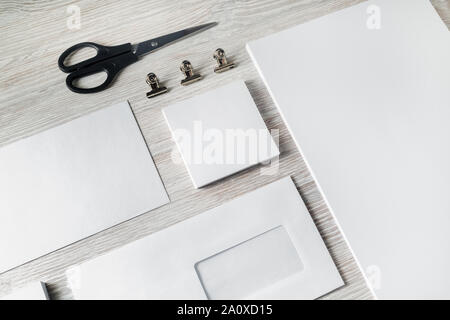 Vuoto bianco set di cancelleria. Marchio aziendale sul modello di luce sullo sfondo di legno. Foto Stock