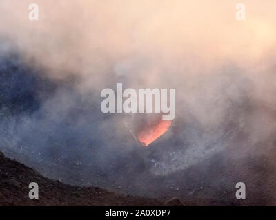 Fumoso scenario del cratere di vulcano Stromboli vicino la Sicilia al tempo di sera Foto Stock