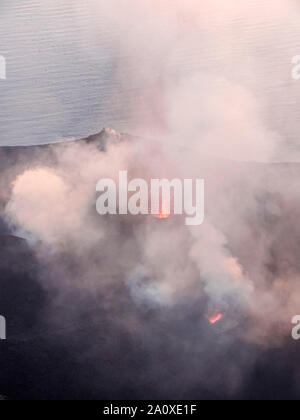 Fumoso scenario del cratere di vulcano Stromboli vicino la Sicilia al tempo di sera Foto Stock